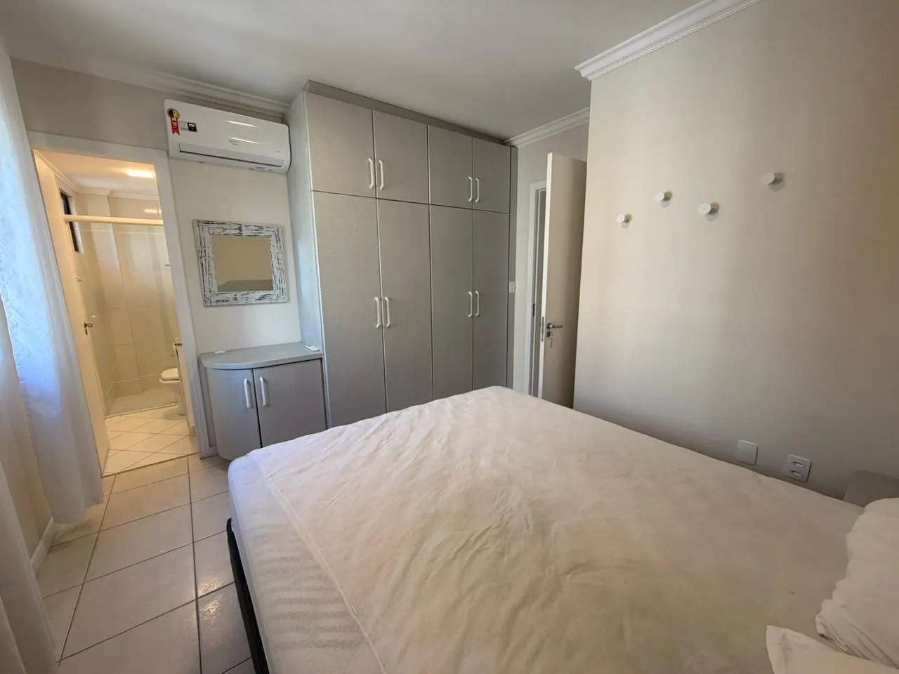 Suíte master com armários planejados e ar-condicionado